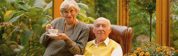 Bild von 2 Senioren zuhause am Tisch.